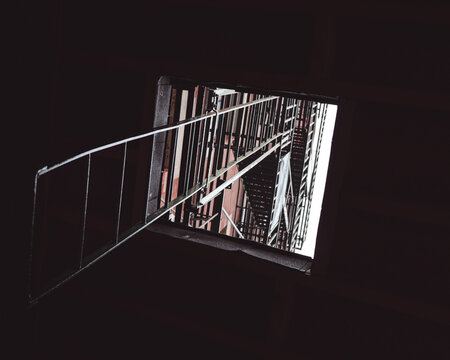 Dark View of New York Fire Escape Through an Open Window