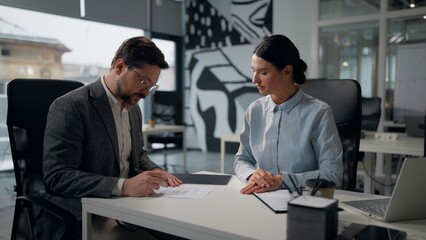 Fototapeta premium Two Caucasian partners shaking hands after conclude successful business contract trading in office businesswoman handshaking with businessman signing document at table cooperation sale trade handshake