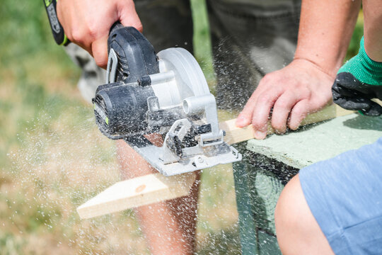 Close up of circular saw cutting wooden board during carpentry work