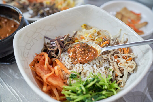 A visual sequence of Korean Doenjang Bori Bibimbap. Thick savory soybean paste is mixed with plump barley rice and colorful assorted vegetables. A hearty, healthy, and authentic local rustic dining.