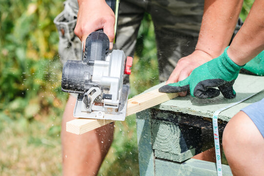 Close up of circular saw cutting wooden board during carpentry work