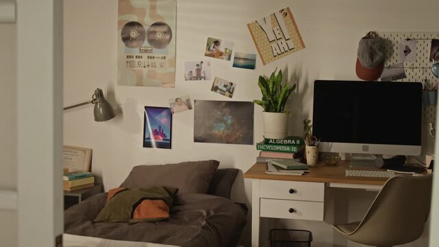 No people shot of teenager bedroom showing study desk with computer, textbooks, and bed during slow camera reveal. Ideal for back-to-school marketing, online learning promos