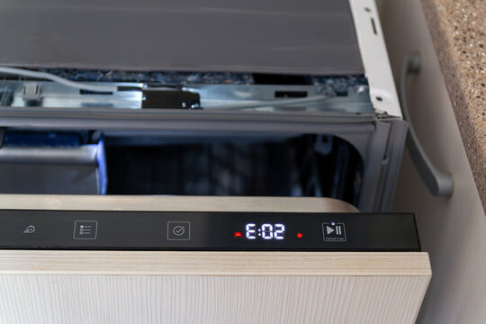 Close up of built-in dishwasher panel displaying technical error or failure during cycle. Broken modern dishwasher machine
