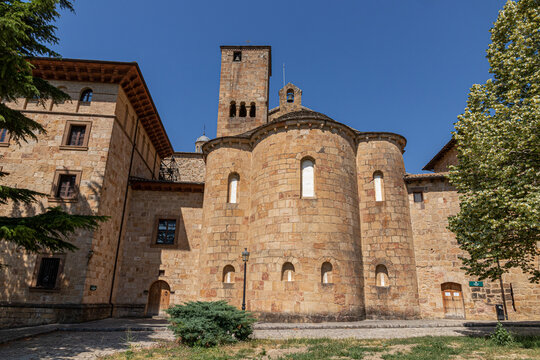 Yesa, Spain. Exterior view of the eleventh century Romanesque three apses and stone bell tower of San Salvador de Leyre monastery against a clear blue sky on a sunny summer day