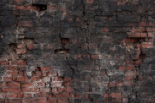 Old charred brick wall texture background with burnt black soot and broken red bricks, damaged rustic brickwork backdrop, grunge war concept, generative AI