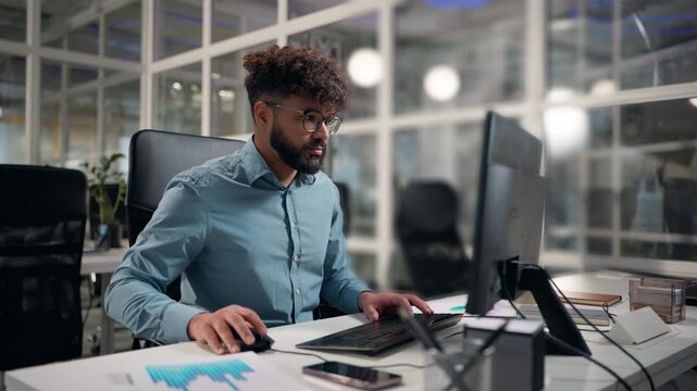 Hindu business man computer chatting with client project developing Arabian businessman using modern technology desktop ethnic guy working in office male executive work documents diagram on table