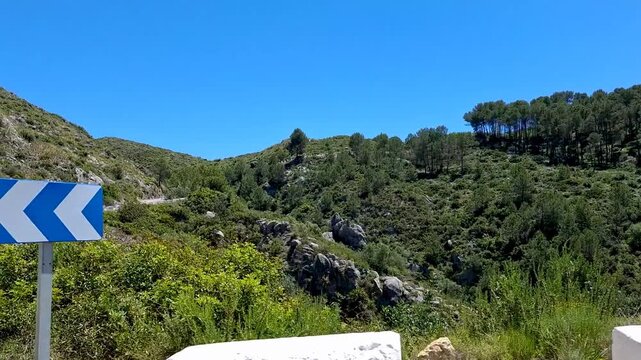 Slow motion view of a winding mountain road serpentine in Vall de Ebo Spain from a driving car