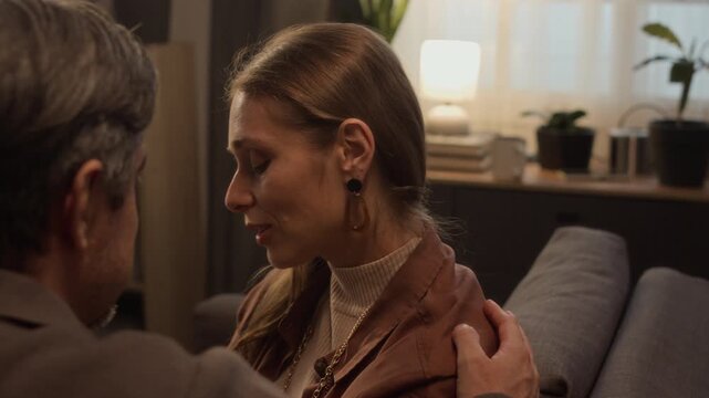 Close up of middle aged Caucasian man comforting crying middle aged Caucasian woman on sofa. Clip ideal for mental health awareness campaigns, relationship counseling, or support services promotion