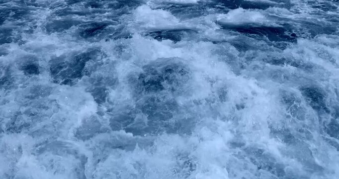 blue whitewater with white foam, textured rapids background, slow motion high angle view and close-up