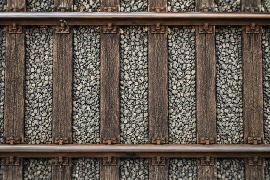 Top-down view of railway sleepers and ballast stones in a geometric pattern.
