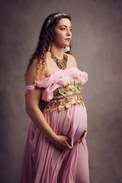 Serene Pregnant Woman as Ancient Greek Goddess in Pink Toga