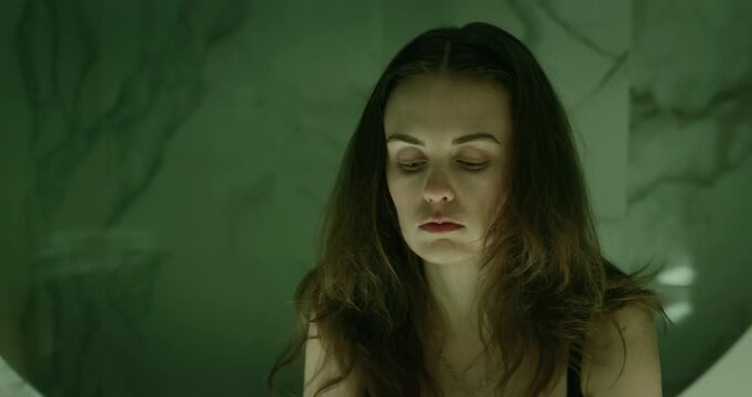 Sad woman wash face dark bathroom. Female person depression feel loneliness stress. Emotional mental health crisis, grief concept. Drug addict problem. Alone girl suffer breakdown, inner struggle pain