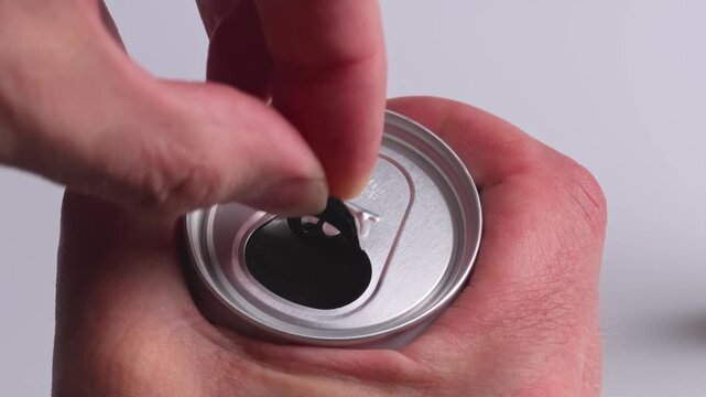 Opening a beer can with hands in a kitchen during a sunny afternoon