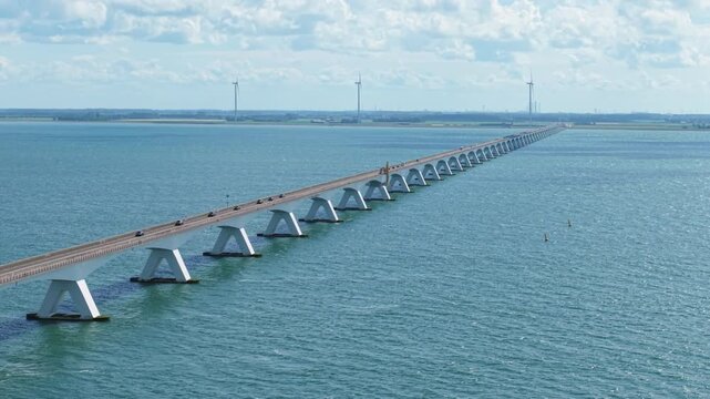 Zeeland Bridge spanning the Oosterschelde estuary with wind turbines and coastal transport in the Netherlands