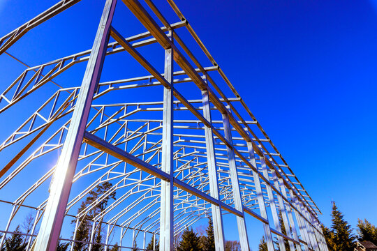 Workers build steel beams structure frame in an open space with framework assembly process