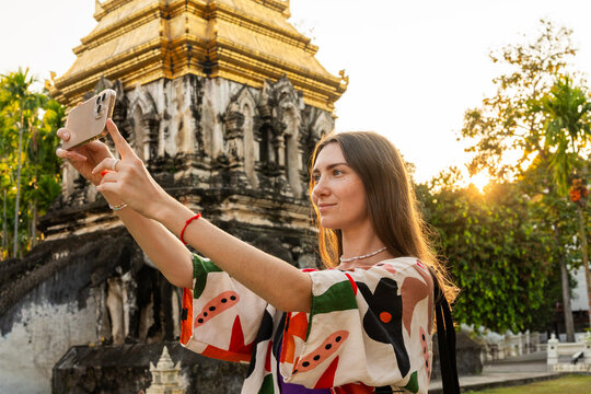 Woman Takes Selfie in Front of Temple During Sunset in Thailand