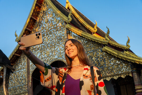 Woman Takes Selfie in Front of Ornate Temple During Sunset