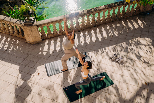 Two women practice yoga on the terrace