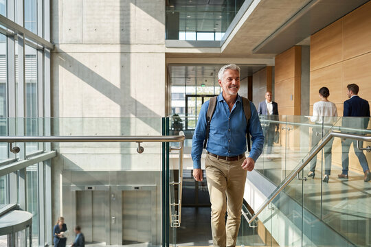 Senior Businessman Walking Through Modern Office Building