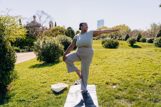 A woman does yoga in a city park