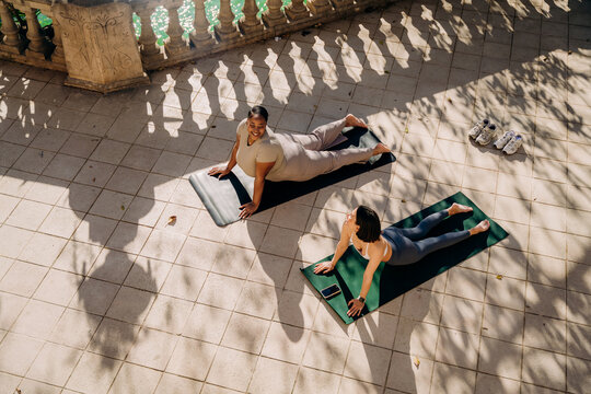 Two women practice yoga on the terrace
