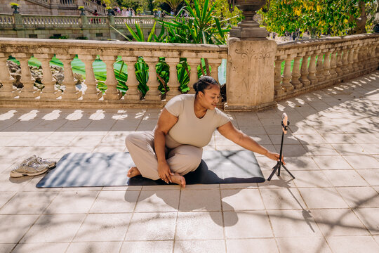 A woman does yoga in a city park