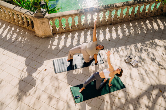 Two women practice yoga on the terrace