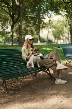 Woman Relaxing on Park Bench With Her Jack Russell Terrier Companion 