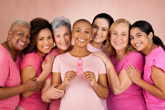 Grupo de mulheres diversas unidas em apoio &agrave; campanha Outubro Rosa segurando la&ccedil;o de cetim - Conceito de conscientiza&ccedil;&atilde;o, preven&ccedil;&atilde;o e luta contra o c&acirc;ncer de mama.