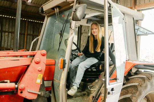 teen girl, young farmer,  posing in her tractor. 