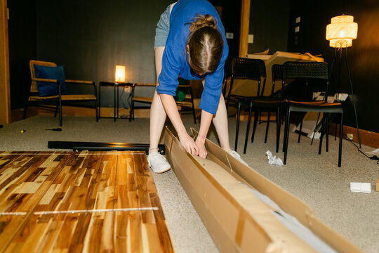 young woman assembling furniture in conference room 