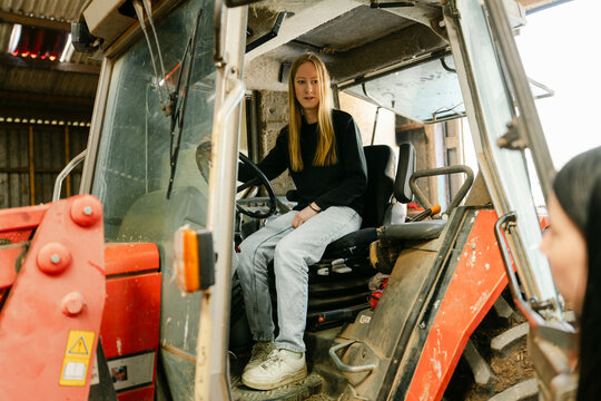 teen girl, young farmer,  posing in her tractor. 