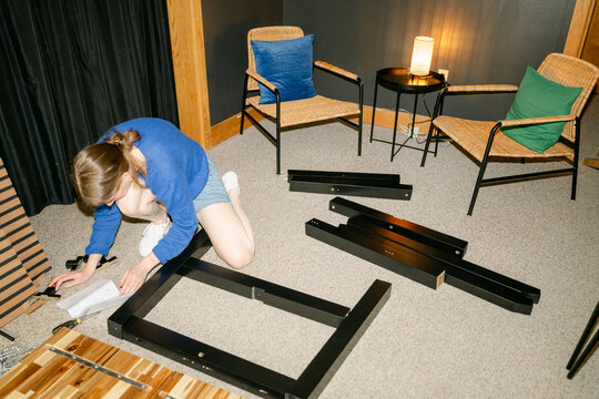 young woman assembling furniture in conference room 