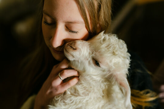 teen girl snuggling an Angora baby goat 
