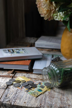 Australian cash notes and coins tipped out of a savings jar at home