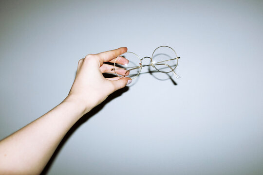 Hand holding rounded shape metallic fashion  glasses with flashlight