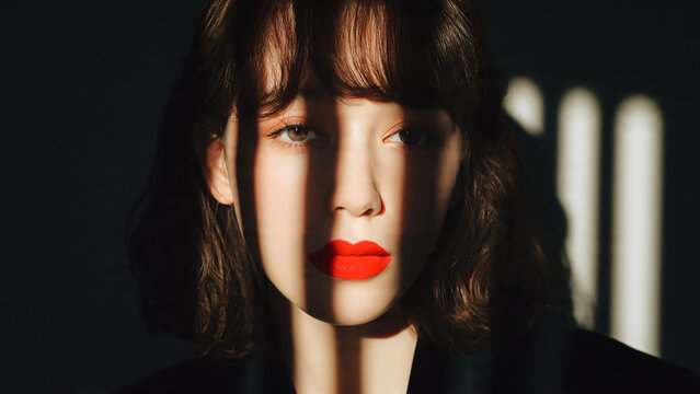 Portrait de jeune femme brune avec rouge a l&egrave;vres et ombre sur le visage
