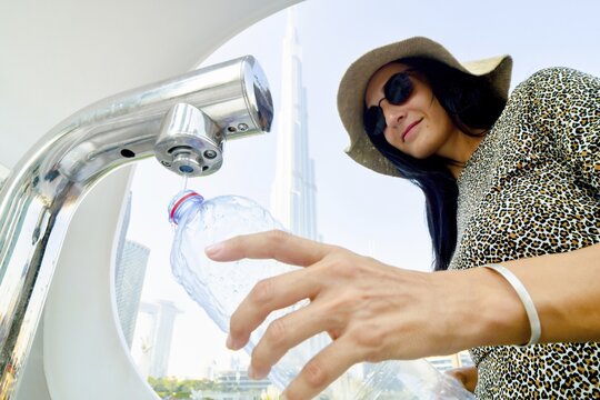 Dubai, UAE - 12th october, 2022: tourist woman use water refill machines in public places for tourist. Save earth save water and reduce plastic concept