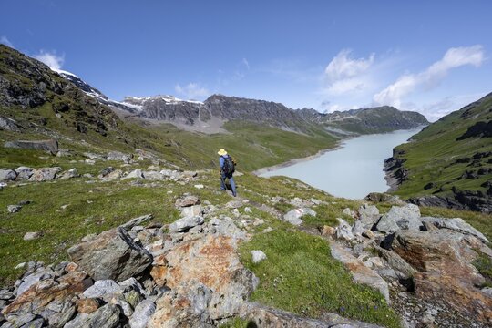 Mountaineer on hiking trail in front of Lac des Dix reservoir, Valais Alps, Valais, Switzerland