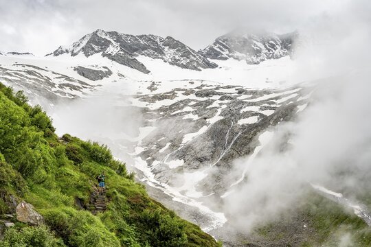 Mountaineers on a hiking trail, behind them cloudy summit Dosso Largo and glacier Schlegeiskees, ascent to Furtschaglhaus, Berliner H&ouml;henweg, Zillertal, Tyrol, Austria