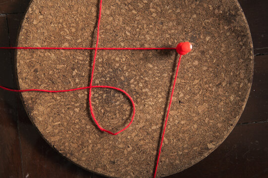 Typography of number 67 created from red pin and thread in style of investigation board