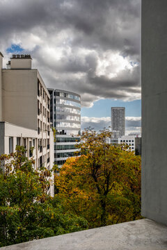 From Paris, France, a city view with buildings and trees frames new sustainable architecture and urban ecology beneath dramatic clouds