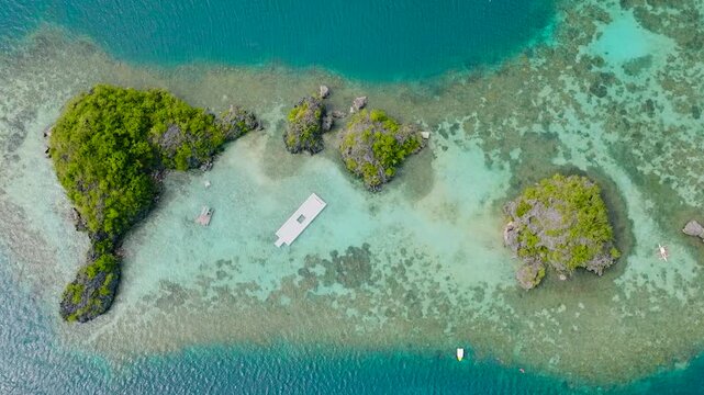 Siete Pecados with coral reefs, boats running over the blue sea. Coron, Palawan. Philippines.