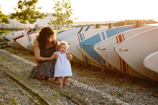 Toddler girl and mother by boats