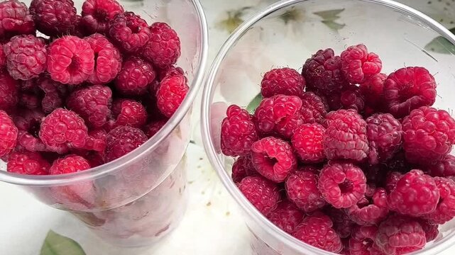Ripe raspberries packed in a plastic package, fresh berry harvest, food packaging, distribution and retail concept.