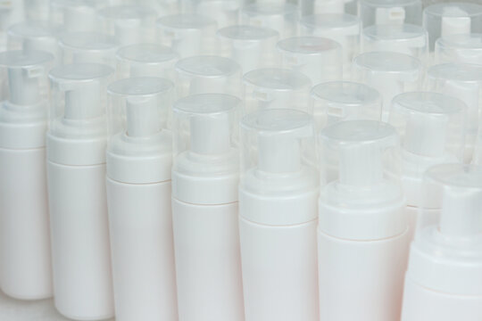 Large number of white plastic bottles. Bottles for cosmetics without labels. Cosmetics production