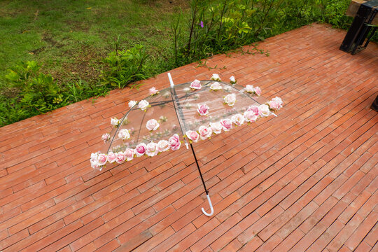 Beautiful Umbrella with flowers in the garden,rain and sun weather on a warm autumn or sumemr day,umbrella under heavy fall shower,Stormy rainy weather season concept.
