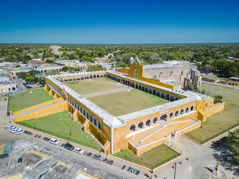 Aerial view of the historic Convento de San Antonio de Padua, featuring iconic yellow walls, a large central courtyard, and arched corridors in Izamal, Yucatan, Mexico.