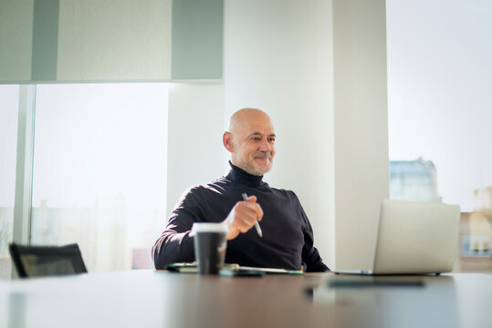Senior executive working on laptop in modern office