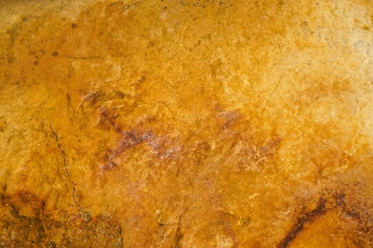 Goldgelb-braune alte verwitterte Backsteinwand mit Muster als Hintergrund